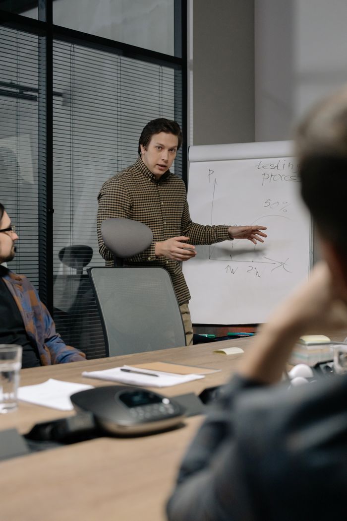 Services Businessman giving a presentation to colleagues in modern office setting, emphasizing teamwork and communication.